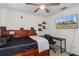 A bedroom with a bed, desk, television, shelves, and a ceiling fan at 3345 Carmen Ave, Spring Hill, FL 34609