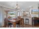 Open dining area features a modern chandelier, wood floors, and access to the kitchen at 3345 Carmen Ave, Spring Hill, FL 34609