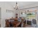 Dining room features hardwood floors, a chandelier, and sliding glass doors to an outdoor patio at 3345 Carmen Ave, Spring Hill, FL 34609