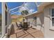 Covered patio with table and chairs overlooking yard through screened enclosure at 3345 Carmen Ave, Spring Hill, FL 34609