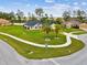Aerial view of a well-maintained home on a large lot, surrounded by lush greenery, landscaped lawns, and a sidewalk at 3455 Whispy Ct, Spring Hill, FL 34609