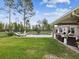 Expansive backyard featuring a pool, covered patio with seating, and a well-maintained lawn, perfect for outdoor activities at 3455 Whispy Ct, Spring Hill, FL 34609