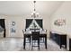 Dining area with dark wood table and chairs, modern chandelier, and a window overlooking the backyard at 3455 Whispy Ct, Spring Hill, FL 34609
