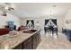 Open-concept kitchen with granite counters, dark cabinets, and stainless steel sink, open to the living and dining area at 3455 Whispy Ct, Spring Hill, FL 34609