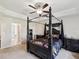 Main bedroom boasts a canopy bed, neutral carpet, and large window with decorative curtains at 3455 Whispy Ct, Spring Hill, FL 34609