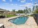 Inviting backyard pool with a waterfall feature, surrounded by a stone patio and lush landscaping for a serene retreat at 3455 Whispy Ct, Spring Hill, FL 34609