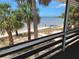 Charming screened-in balcony view features palm trees and the serene beachfront, perfect for relaxation at 3461 Gum Dr, Weeki Wachee, FL 34607