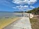 Waterfront property featuring beach access, clear water, and lush tropical foliage with a stunning cloudscape on a sunny day at 3461 Gum Dr, Weeki Wachee, FL 34607