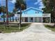 Blue beach house with palm trees and beach access at 3461 Gum Dr, Weeki Wachee, FL 34607