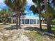 Exterior view showcasing a blue raised home with white railings and mature trees around property at 3461 Gum Dr, Weeki Wachee, FL 34607