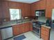 Modern kitchen featuring stainless appliances, granite counters, and wooden cabinets at 3461 Gum Dr, Weeki Wachee, FL 34607