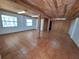 Spacious living area featuring tile flooring, natural lighting, and wooden support beams at 3461 Gum Dr, Weeki Wachee, FL 34607