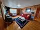 Cozy living room features wood paneled walls, a red sofa, and nautical themed decor at 3461 Gum Dr, Weeki Wachee, FL 34607