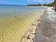 Waterfront view of sandy beach and clear water alongside a concrete walkway at 3461 Gum Dr, Weeki Wachee, FL 34607