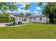 Backyard view of a house with a well-manicured lawn, a palm tree and a white exterior at 4035 Fairfield S Ave, St Petersburg, FL 33711
