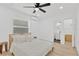 Bright bedroom features wood-look floors, modern ceiling fan, and an ensuite bathroom at 4035 Fairfield S Ave, St Petersburg, FL 33711