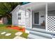 Inviting front porch with lattice detail, red bark, a grey door, and well-kept lawn at 4035 Fairfield S Ave, St Petersburg, FL 33711