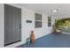 Cozy front porch featuring a gray door, decorative vases, and a wicker chair at 4035 Fairfield S Ave, St Petersburg, FL 33711