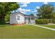 Landscaped front yard showcasing green lawn, mature shrubbery, and stone-textured white exterior at 4035 Fairfield S Ave, St Petersburg, FL 33711