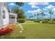 Beautifully landscaped front yard with green grass, palm trees in the distance, and stepping stones at 4035 Fairfield S Ave, St Petersburg, FL 33711