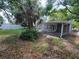 A spacious backyard with a covered patio, a palm tree, and ample space for outdoor activities at 4118 Flamingo Dr, New Port Richey, FL 34652