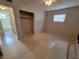 A bedroom featuring terrazzo floors, a ceiling fan, and a view of an open closet at 4118 Flamingo Dr, New Port Richey, FL 34652