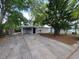 Inviting front exterior featuring mature trees, a covered entryway, and well-kept landscaping at 4118 Flamingo Dr, New Port Richey, FL 34652