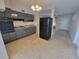 Kitchen featuring gray cabinets, black appliances, and terrazzo flooring at 4118 Flamingo Dr, New Port Richey, FL 34652