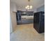 Kitchen featuring gray cabinets, black appliances, and terrazzo flooring at 4118 Flamingo Dr, New Port Richey, FL 34652