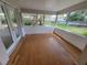 Bright sunroom with wood floors and multiple windows offering backyard views at 4118 Flamingo Dr, New Port Richey, FL 34652