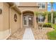 Close up of the inviting front door with decorative palm trees and easy access walkway with stone at 4335 Canongate Ct, Spring Hill, FL 34609