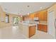 Open kitchen with central island, wood cabinets, stainless appliances, and direct access to the outdoor patio at 4335 Canongate Ct, Spring Hill, FL 34609