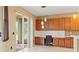 Sunlit kitchen with a built-in desk area, wood cabinets, pendant lighting, and easy access to the patio at 4335 Canongate Ct, Spring Hill, FL 34609