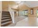 Spacious living room with carpet, staircase, vaulted ceilings, and seamless transition to the tiled kitchen at 4335 Canongate Ct, Spring Hill, FL 34609