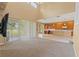 Open-concept living room boasts plush carpet, lots of natural light, and seamless transition to the modern kitchen at 4335 Canongate Ct, Spring Hill, FL 34609