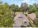 An aerial view of a well-kept single-Gathering house with mature trees and a front-facing two-car garage at 4407 Caliquen Dr, Brooksville, FL 34604