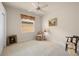 Bright bedroom features art, ceiling fan, and two chairs at 4407 Caliquen Dr, Brooksville, FL 34604