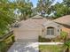 Charming single-story home featuring a two-car garage, well-manicured lawn, and mature landscaping at 4407 Caliquen Dr, Brooksville, FL 34604