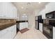 White kitchen featuring stainless appliances, tile backsplash, and ample counter space at 4407 Caliquen Dr, Brooksville, FL 34604