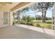 Screened lanai with a ceiling fan and scenic view of a grassy lawn and trees at 4407 Caliquen Dr, Brooksville, FL 34604