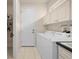 Laundry room with white washer and dryer, cabinets, and access to shelving space at 4407 Caliquen Dr, Brooksville, FL 34604