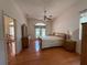 Bright primary bedroom featuring wood floors, ceiling fan, and access to outdoor pool area at 4450 Anaconda Dr, New Port Richey, FL 34655