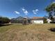 Back exterior showcasing the screened-in pool enclosure and spacious yard, perfect for outdoor living and enjoying the surrounding nature at 4450 Anaconda Dr, New Port Richey, FL 34655