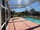 Enclosed screened pool area with clear blue water, lounge chair, and plenty of space for entertaining and relaxation at 4450 Anaconda Dr, New Port Richey, FL 34655