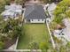 Aerial view showcasing the backyard with a large grassy area, the home's layout, and the surrounding landscape at 461 Pent St, Tarpon Springs, FL 34689
