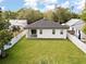 Spacious backyard featuring a well-maintained lawn, privacy fence, and covered patio at 461 Pent St, Tarpon Springs, FL 34689