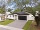 Single-story home with well-maintained lawn and driveway, complemented by mature trees at 461 Pent St, Tarpon Springs, FL 34689