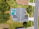 Aerial view of a home with screened in pool, well maintained lawn, and mature landscaping at 473 Tournament Dr, Spring Hill, FL 34608