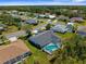 Aerial view of a home with a screened-in pool and a spacious backyard in a lovely neighborhood at 473 Tournament Dr, Spring Hill, FL 34608