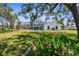 Expansive backyard featuring an enclosed pool area, grassy lawn, and serene landscaping at 473 Tournament Dr, Spring Hill, FL 34608